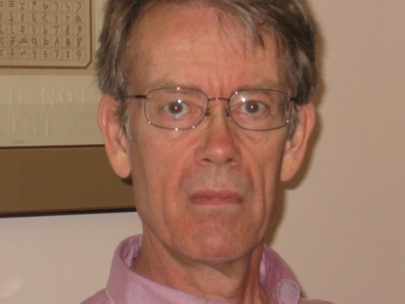 Duncan wearing a light pink button up and sunglasses