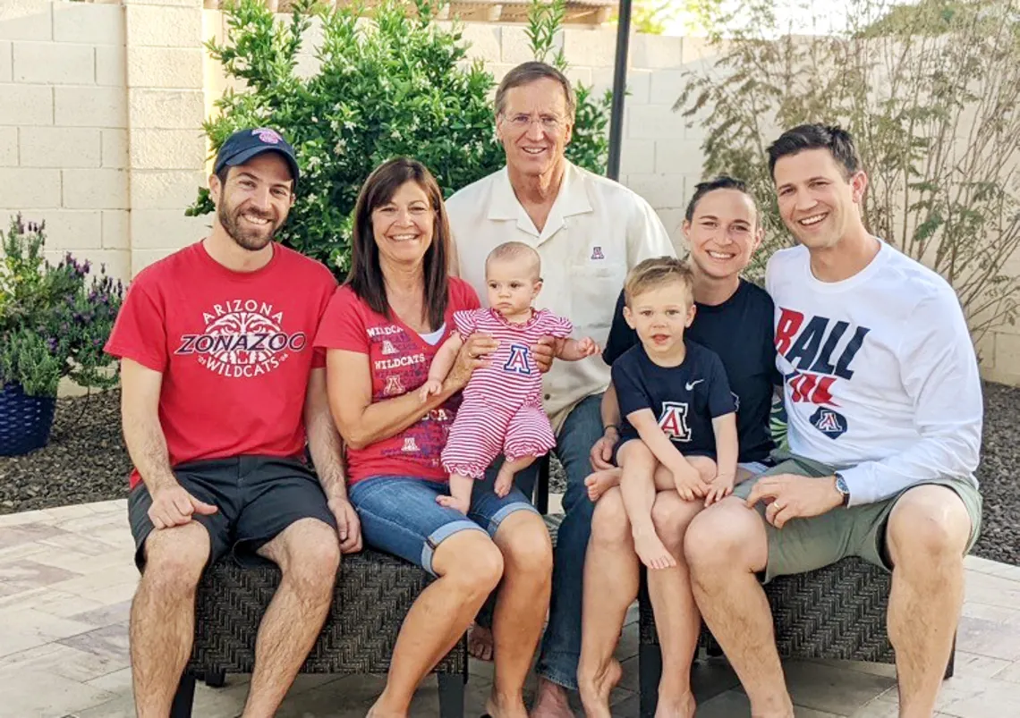 A photograph of Mike and Sheri Hummel sporting UArizona gear with their sons and grandchildren.