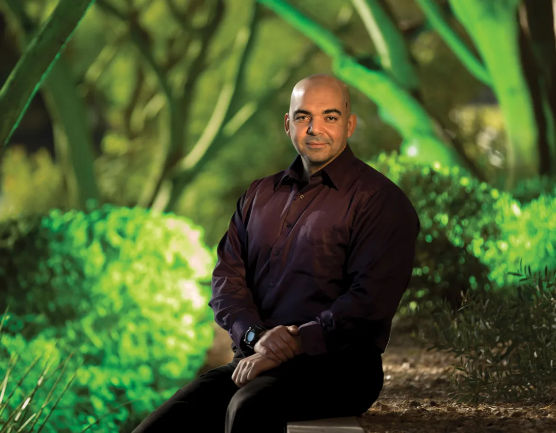 A photograph of Mohab Ibrahim sitting in front of a green backdrop