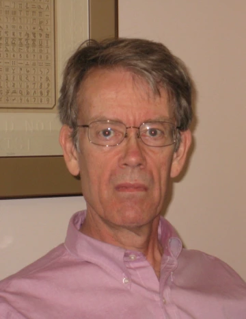 Duncan wearing a light pink button up and sunglasses