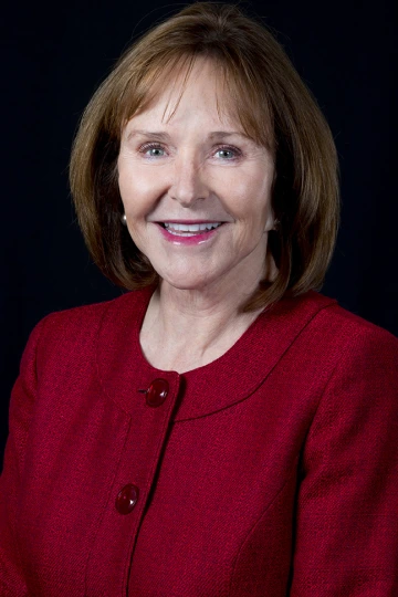 Jan smiling, wearing a red button up shirt
