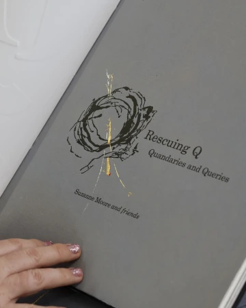 The title page of book with a large, stylized Q and text that reads: “Rescuing Q: Quandaries and Queries, Suzanne Moore and friends”